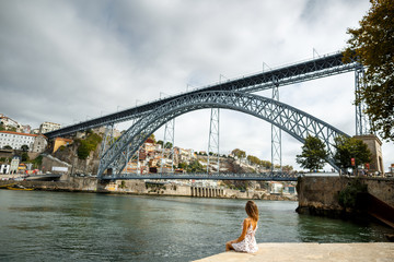 Young woman tourist sitting with great cityscape view on Porto city in Portugal