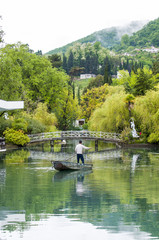 A small beautiful lake. The boatman, skating on the lake.