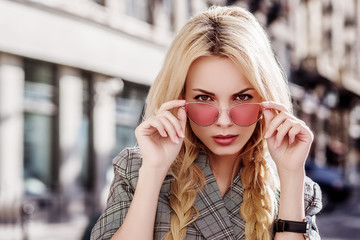 Outdoor close up portrait of young beautiful confident fashionable girl wearing stylish pink cat...
