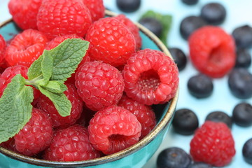 Raspberries and blueberries in a bowl.
