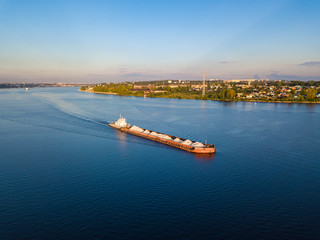Aerial view carrier ship on river Volga. Cargo ship near Kostroma city at sunset.
