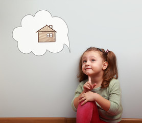 Fun thinking kid looking up on idea cloud bubble with new future house inside on blue background....
