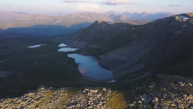 Mountain lake aerial view. Clip. Beautiful panorama of the mountain landscape with amazing pond. Flying a quadcopter over a mountain lake.