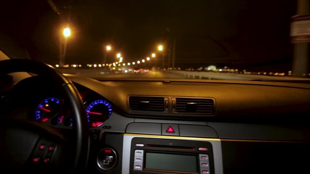 Night city time lapse driving. Timelapse of driving at night with camera in car. Man drives in car salon on high-speed highway at night, time lapse. Night driving