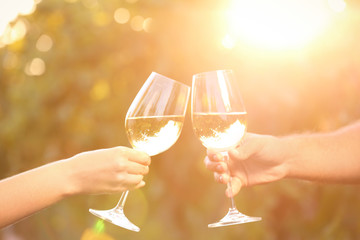 Couple with glasses of white wine outdoors, closeup