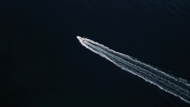 Aerial - Top down tracking shot of motorboat leaving white foam track - SM