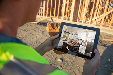 Female Construction Worker Reviewing Kitchen on Computer Pad at Construction Site