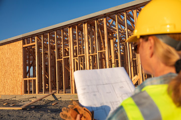 Female Construciton Worker with House Plans at Construciton Site