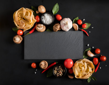 Fettuccine tagliatelle paste and slate board with mushrooms, herbs and spices