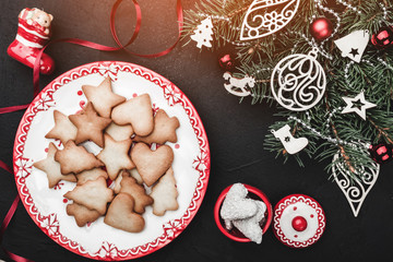 Christmas card. A plate of sweet home biscuits. A Christmas tree toy decorated with toys. Top view