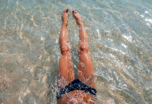 Young woman lying in the water in the beach.