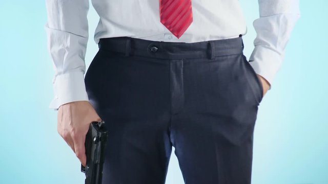 4K. Slow motion. Close-up. Colorful background. A young man holds a gun in his hands