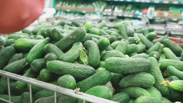 A woman in a supermarket buying vegetables