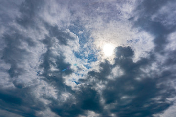 Blauer Himmel mit Wolken und Sonne. Schöner Sommerhimmel