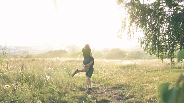 young loving couple in nature in summer on a background of leaves , there is noise on the video