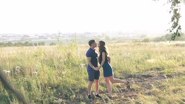 young loving couple in nature in summer on a background of leaves , there is noise on the video