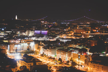 Beautiful night super wide-angle aerial view of Lisbon, Portugal with harbor and skyline scenery beyond the city, shot from  belvedere observation deck