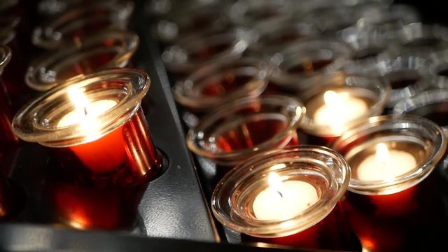 Świeczka oraz lampiony zapalone w kościele