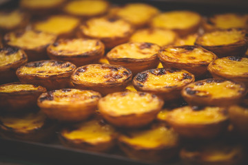 Traditional Portuguese egg tart pasty cakes, dessert Pasteis de nata with different portuguese pastry on the cafe store window, pastel de nata