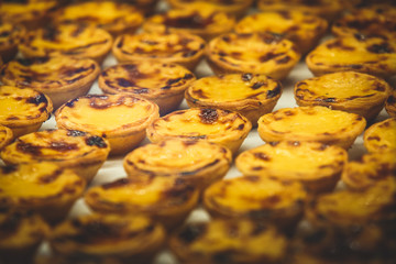 Traditional Portuguese egg tart pasty cakes, dessert Pasteis de nata with different portuguese pastry on the cafe store window, pastel de nata