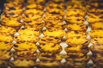 Traditional Portuguese egg tart pasty cakes, dessert Pasteis de nata with different portuguese pastry on the cafe store window, pastel de nata