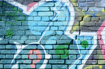 Fragment of graffiti drawings. The old wall decorated with paint stains in the style of street art culture. Colored background texture in cold tones