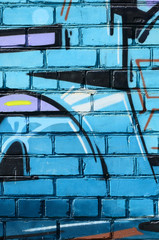 Fragment of graffiti drawings. The old wall decorated with paint stains in the style of street art culture. Colored background texture in cold tones