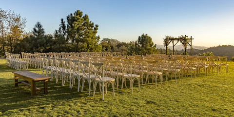 Fototapeta premium Chairs and Chuppah on a lawn with stunning view