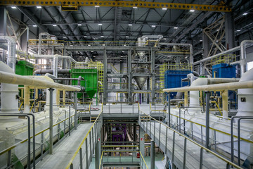Inside modern Chemical factory. Thermoplastic production line. Industrial equipment, cables, vats and piping