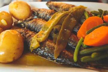 Close-up of portugese traditional grilled sardines sardinas on a plate with potatoes and vegetables, in Lisbon, Potrugal