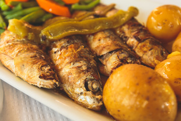 Close-up of portugese traditional grilled sardines sardinas on a plate with potatoes and vegetables, in Lisbon, Potrugal