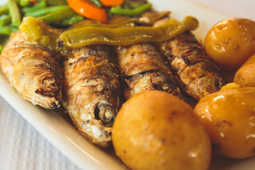 Close-up of portugese traditional grilled sardines sardinas on a plate with potatoes and vegetables, in Lisbon, Potrugal