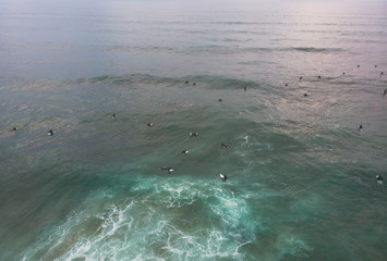 Obraz premium View of Praia do Guincho, Guincho beach, a popular Atlantic Ocean beach on Portugal's Estoril coast, municipality of Cascais, with surfers surfing on the waves, shot from drone