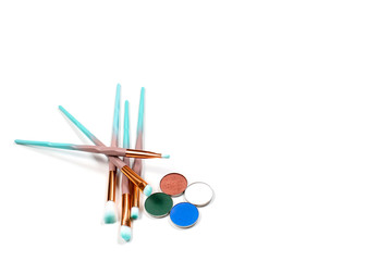 isolated colourful makeup eye brushes kit mint blue with skin powder top view on white