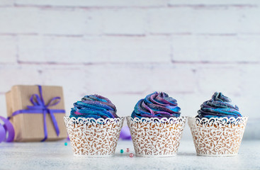 Cupcakes with galaxy whipped cream on party background with copyspace