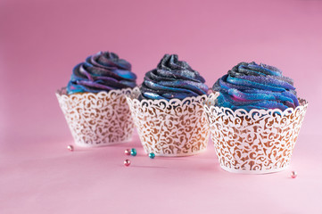 Galaxy cupcakes on pink background with copyspace