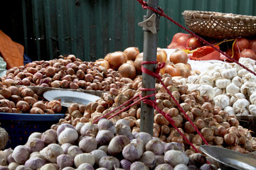 Garlic and shallots in local vendor market with foreground out of focus