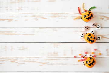 Top view of white and yellow ghost pumpkins with  jelly worm on white wooden background. halloween concept.