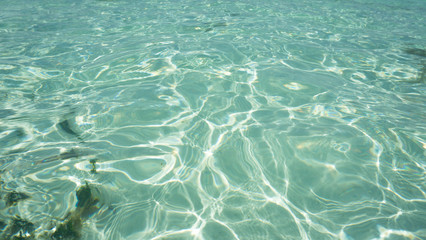 water ripple on the sea beach with green color and reflection