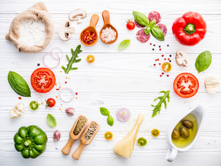 The ingredients for homemade pizza on white wooden background.