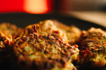 Fried vegetable fritters with zucchini, carrots, herbs, eggs, and cheese.