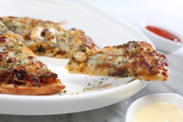 The pizza is in a white tile dish. On a white background in a studio