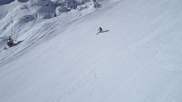 Aerial - Side view tracking shot of good alpine skier skiing down the ski slope