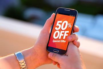 50% OFF Sale. Girl holding a smartphone with a 50% discount advertising on the screen. Marketing, ecommerce, cell phone publicity.