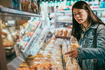 female customer is holding a bag of dried fruit.