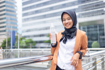 Fototapeta premium Beautiful young asian muslim with bottled water.