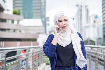 business muslim woman using phone in city.