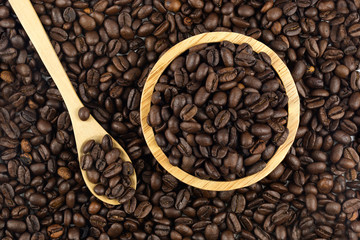 Coffee beans in wood bowl with spoon , Top view