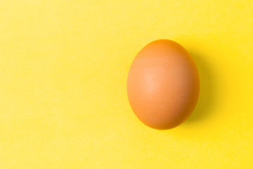 single egg on yellow background, copy space