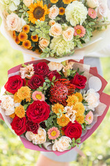 bright and delicate, two beautiful bouquet. Young girl holding a flowers arrangements with variety of colors. Bright dawn or sunset sun